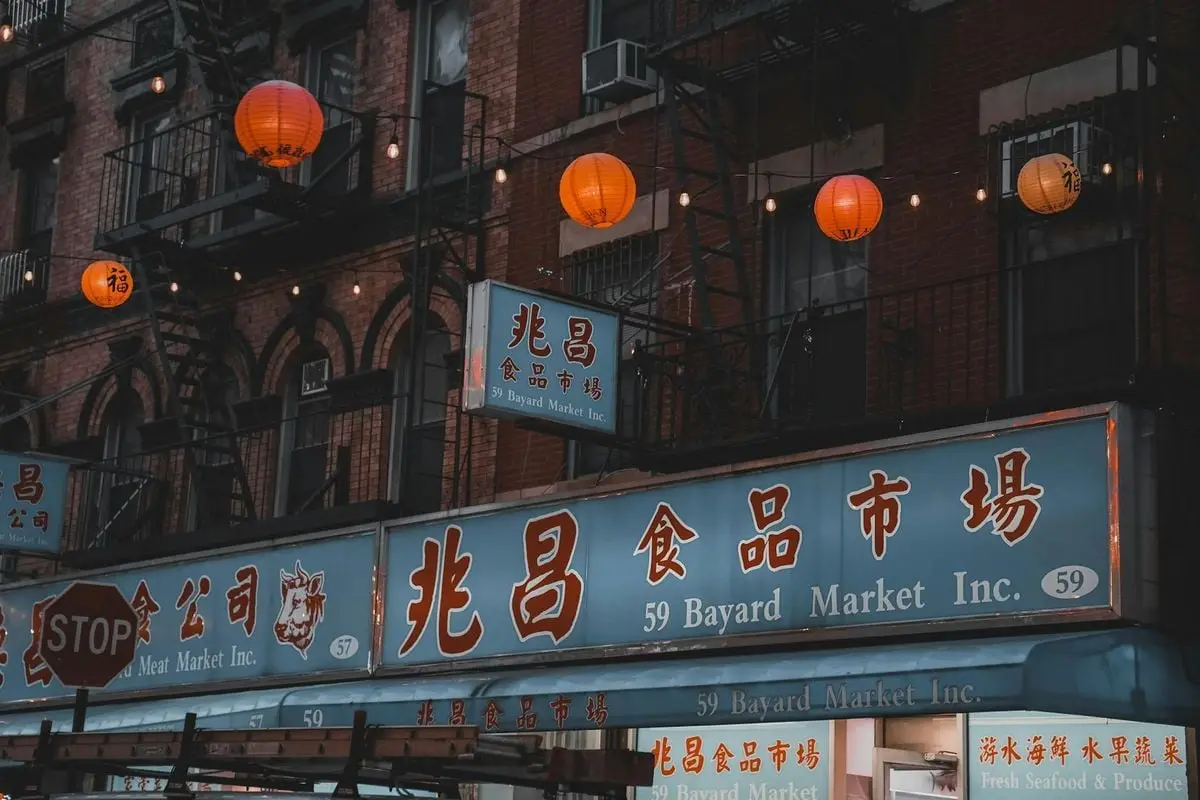 Chinatown buildings in New York City adorned with vibrant lanterns and signs.