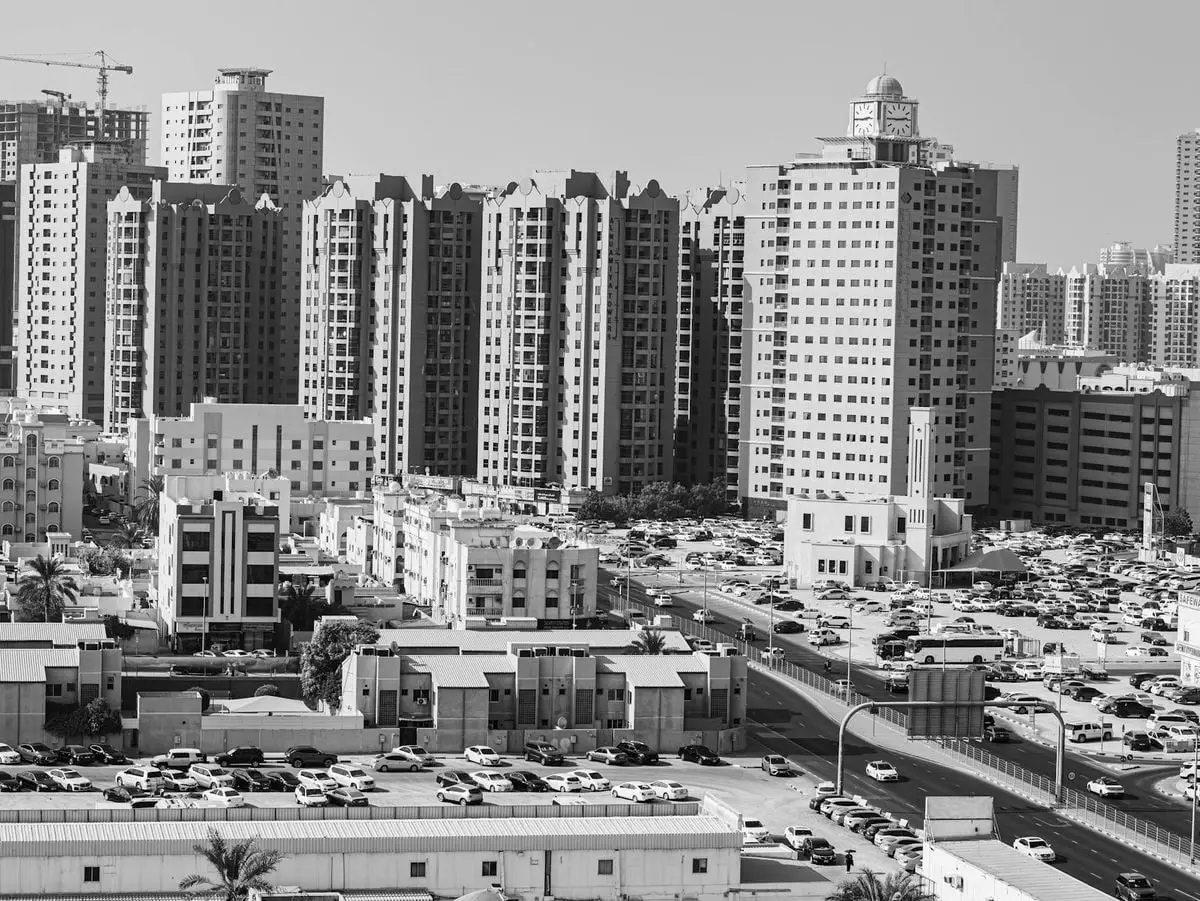 Aerial view of Ajman cityscape with high-rise buildings in black and white.