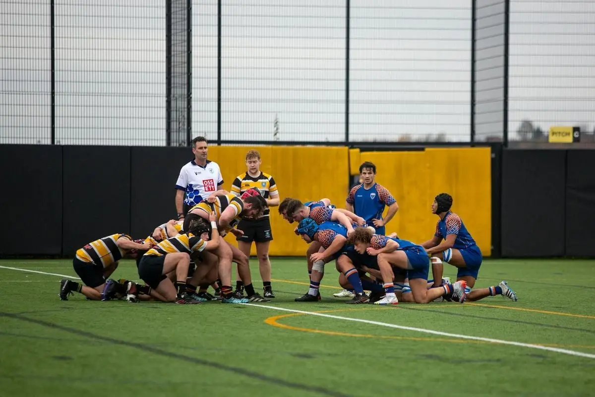 Teams competing in a dynamic rugby match at the university level.
