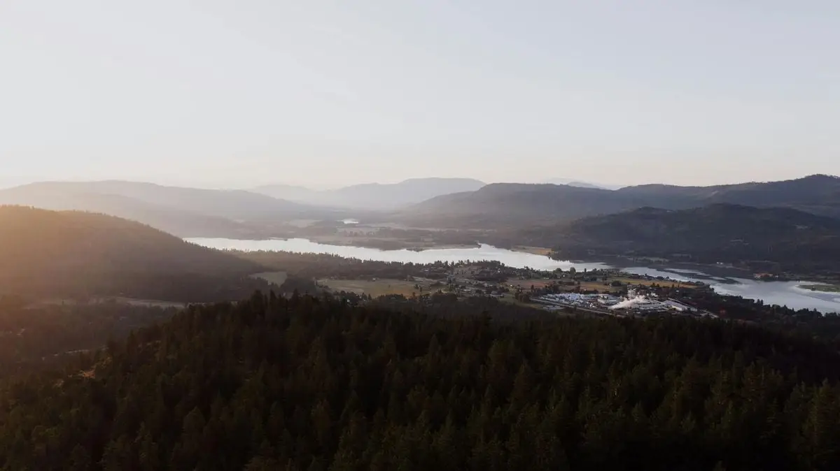 Stunning aerial view of Priest River, Idaho at sunrise with mountains and forests.