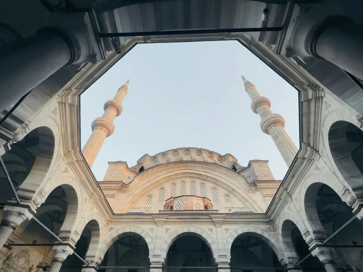 A stunning low-angle view of a mosque's architecture featuring domes and minarets in Istanbul, Turkey.