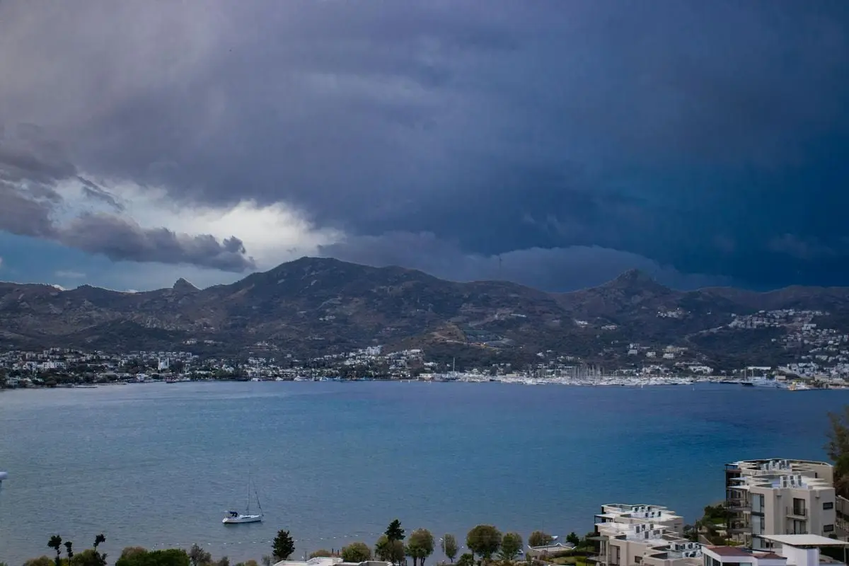 Dramatic storm clouds loom over Yalıkavak Bay, showcasing the serene yet captivating coastline of Muğla, Türkiye.