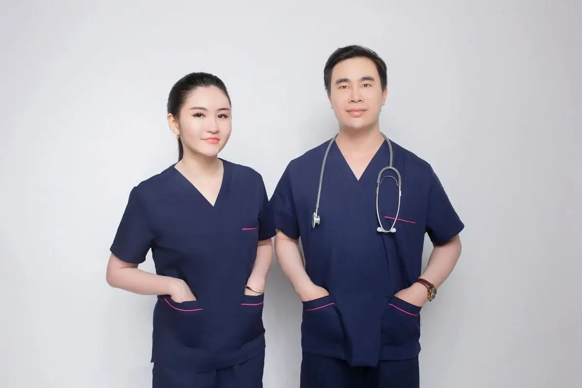Portrait of a confident male and female medical practitioners in uniform with stethoscope.