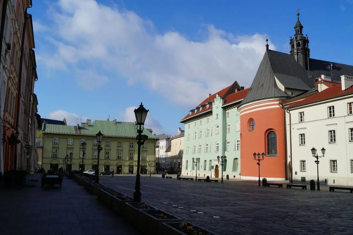 Discover the beauty of Kraków's Small Market Square with colorful townhouses and Renaissance architecture.