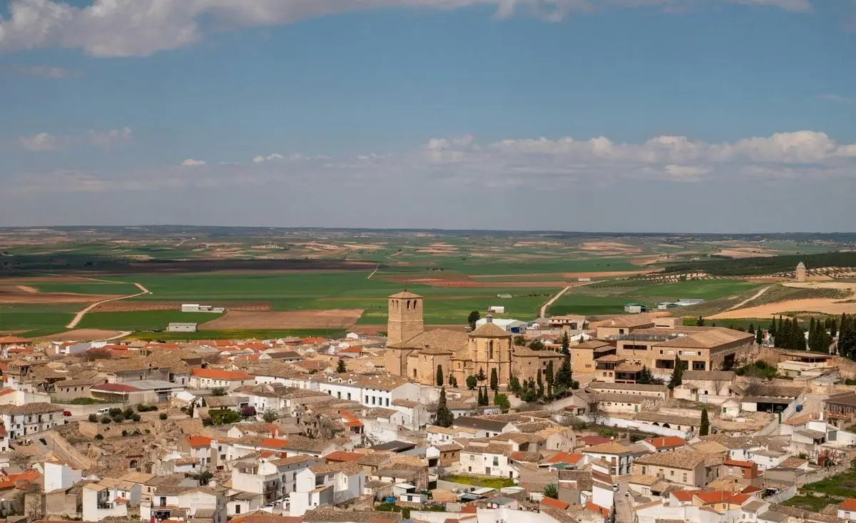 Aerial view of a picturesque Spanish village and countryside under a sunny sky.