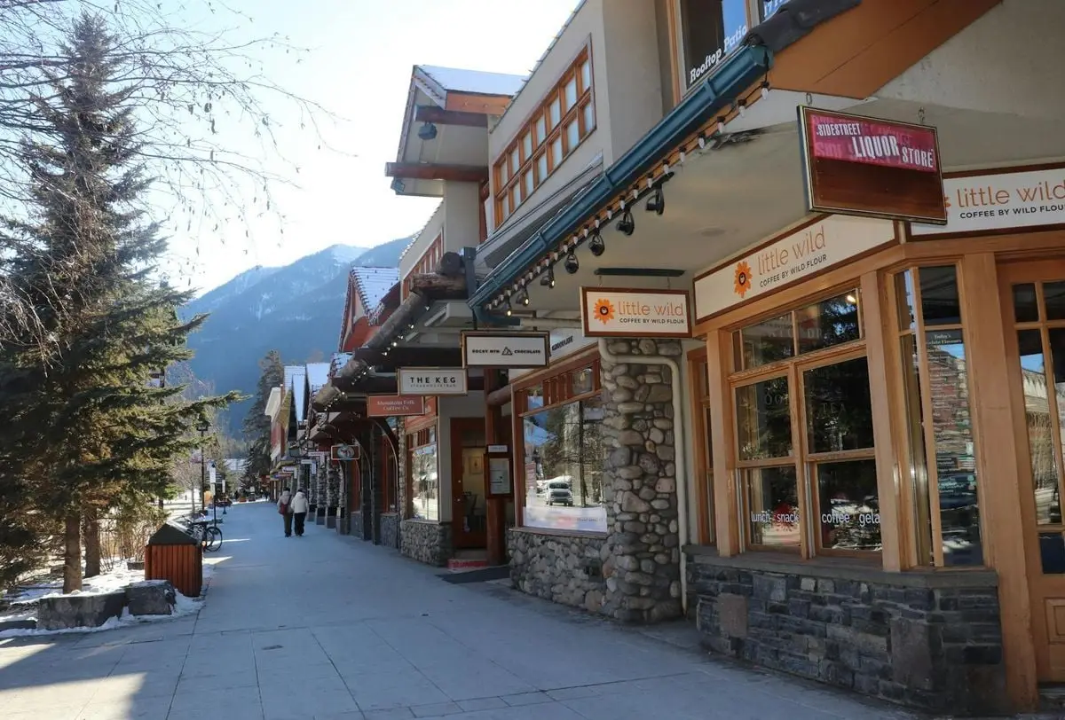 A scenic street view in Banff with shops, showing mountains in the backdrop. Ideal for travel enthusiasts.