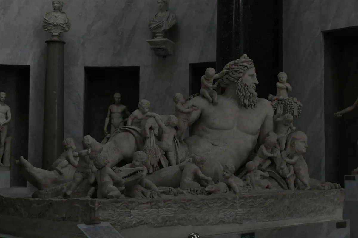Detailed marble sculpture depicting historical figures in a classical museum setting.