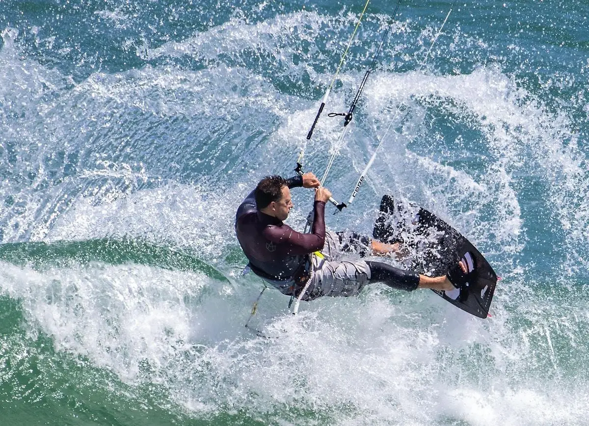 Thrilling kite surfer catching air amid ocean waves in Cape Town, South Africa.