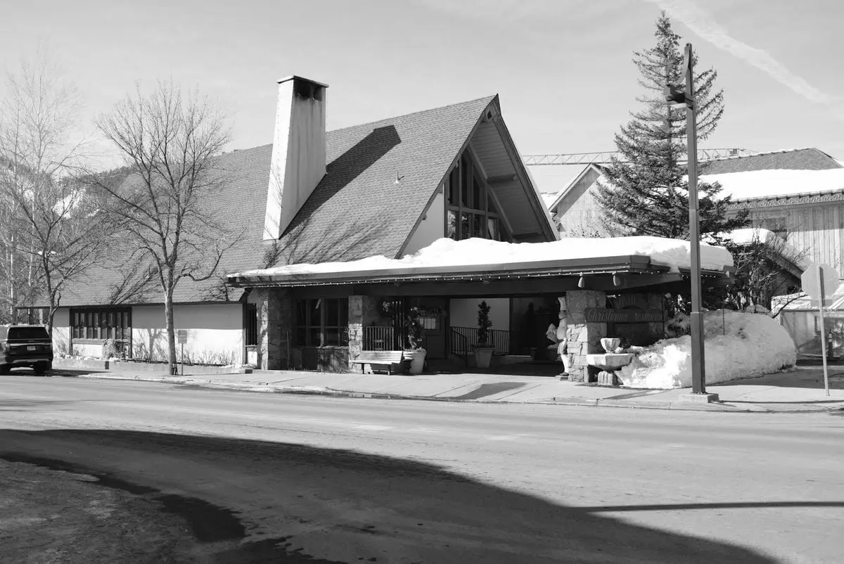 Black and white photo capturing a snow-covered building on a street in Ketchum, Idaho.
