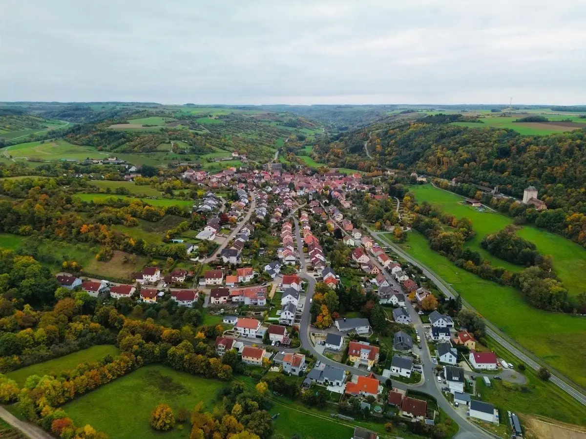 Beautiful aerial shot of a European village surrounded by rolling hills in autumn.