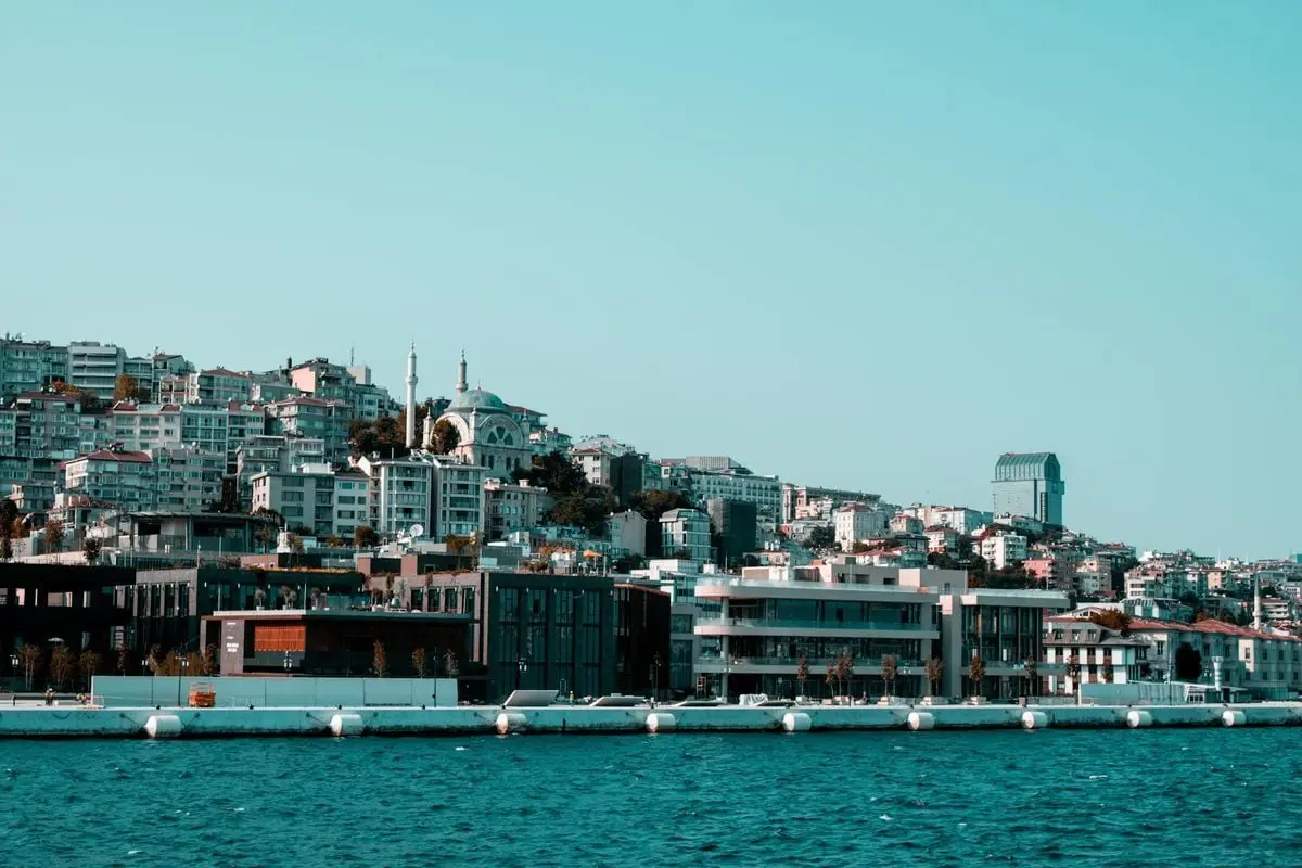 Scenic view of a city skyline along the coast featuring modern and traditional architecture.