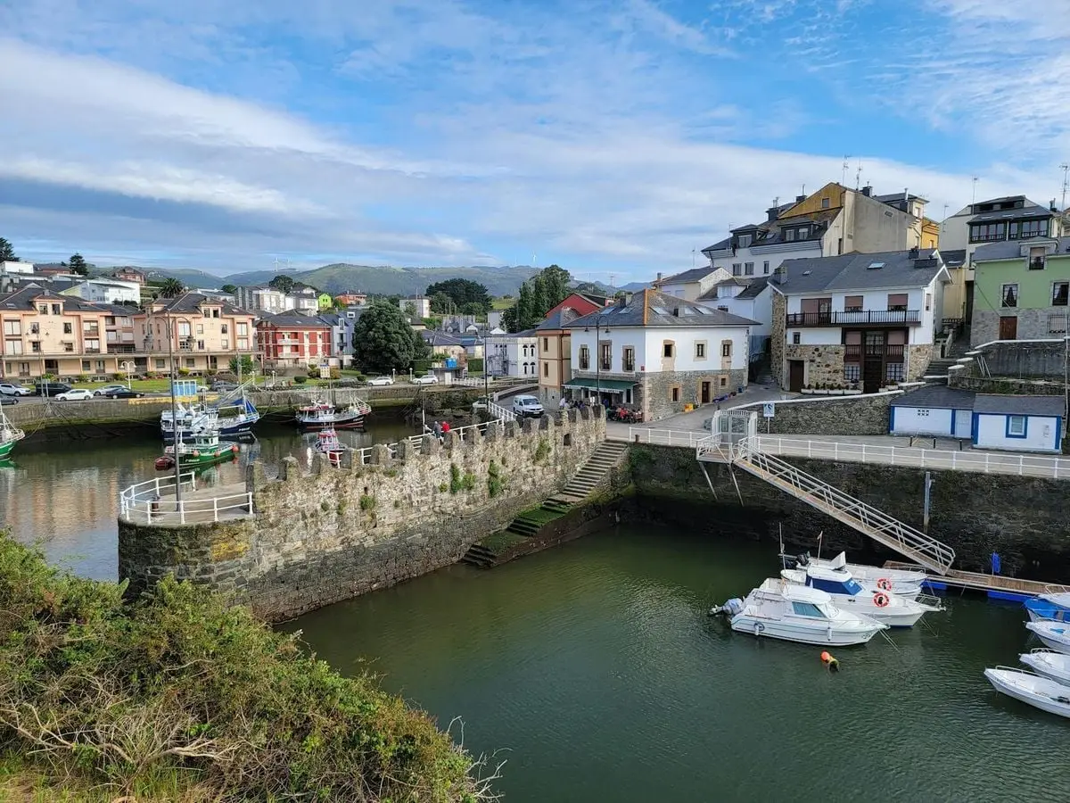 Scenic view of a picturesque coastal village in Spain with boats by the water and charming architecture.