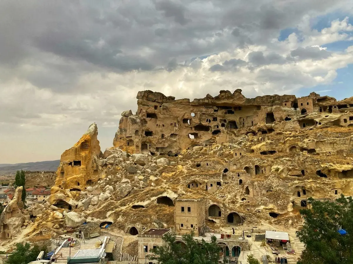 Explore the historic rock formations and cave homes in Cavusin, Turkey, a captivating travel destination.