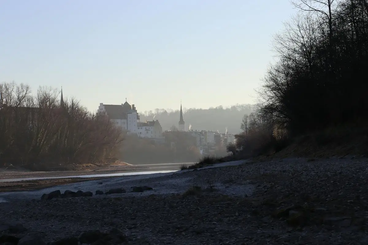 Wasserburg, Germany, townscape with misty river and leafless trees creating a serene winter scene.