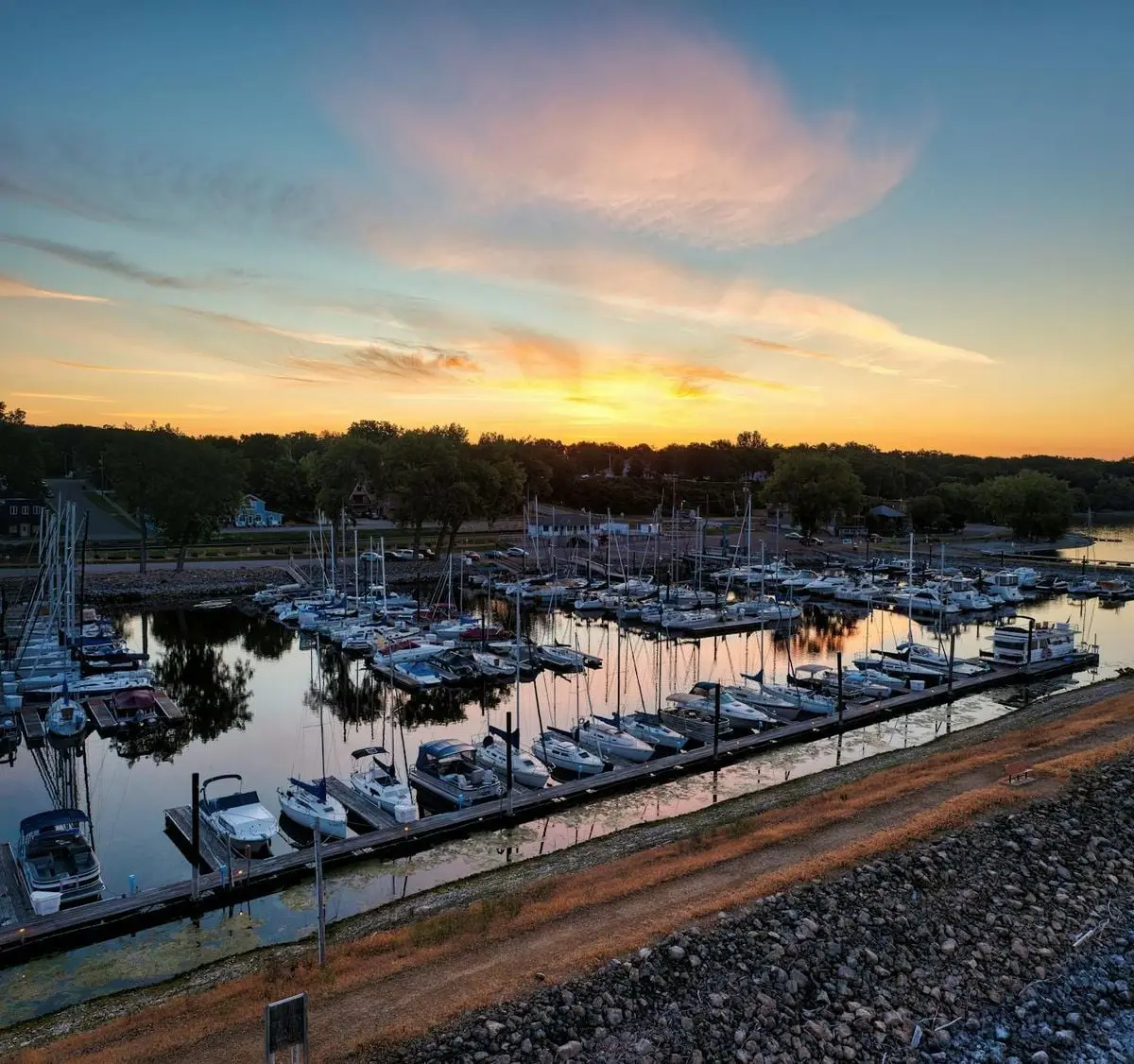 Stunning aerial view of a marina with boats docked during a vibrant sunset in Pepin, Wisconsin.