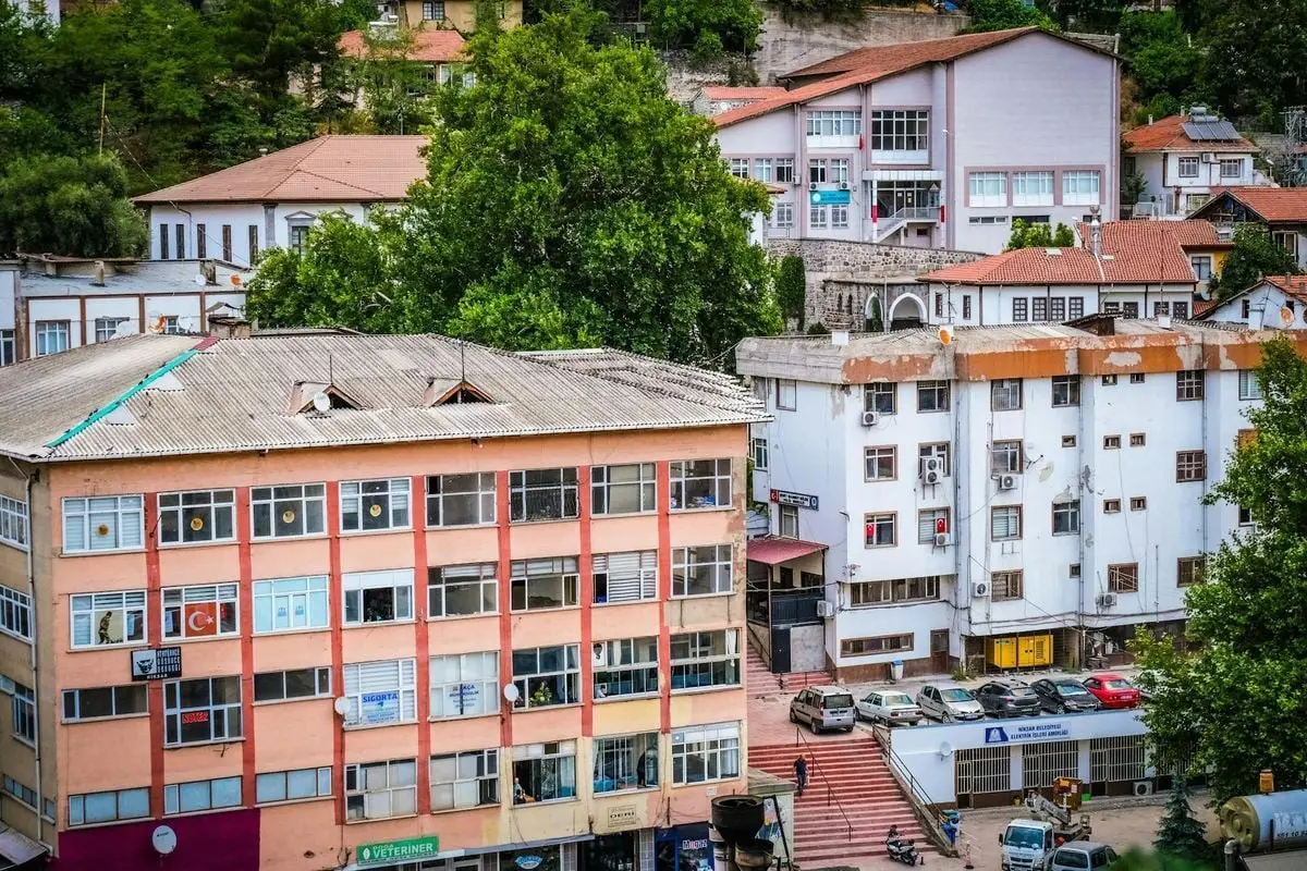 Colorful urban residential buildings with Turkish flag in a green neighborhood.