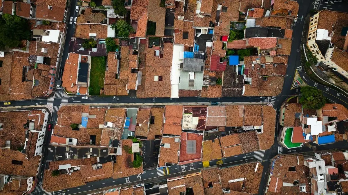 Aerial photograph showing red-tiled rooftops and winding streets of a town.