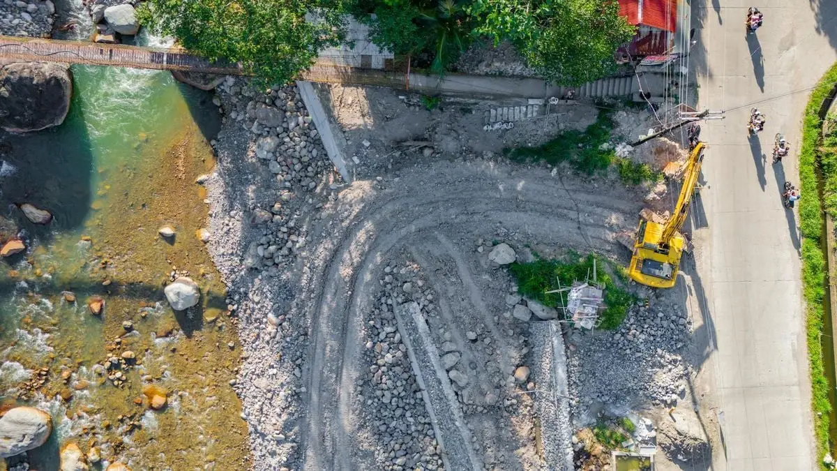 Aerial view of a construction site with excavators and river, Cebu City, Philippines.