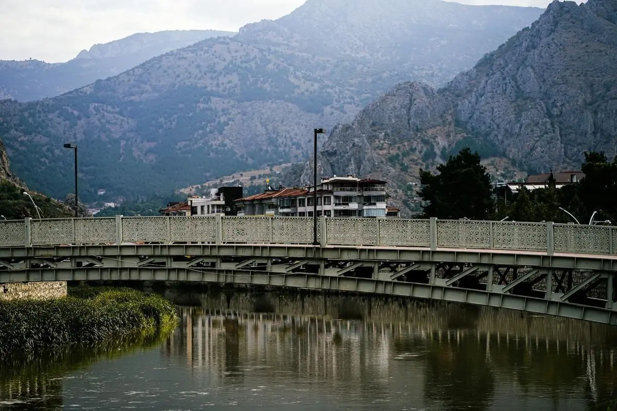 Picturesque bridge over river in Amasya with rocky mountains in the background.