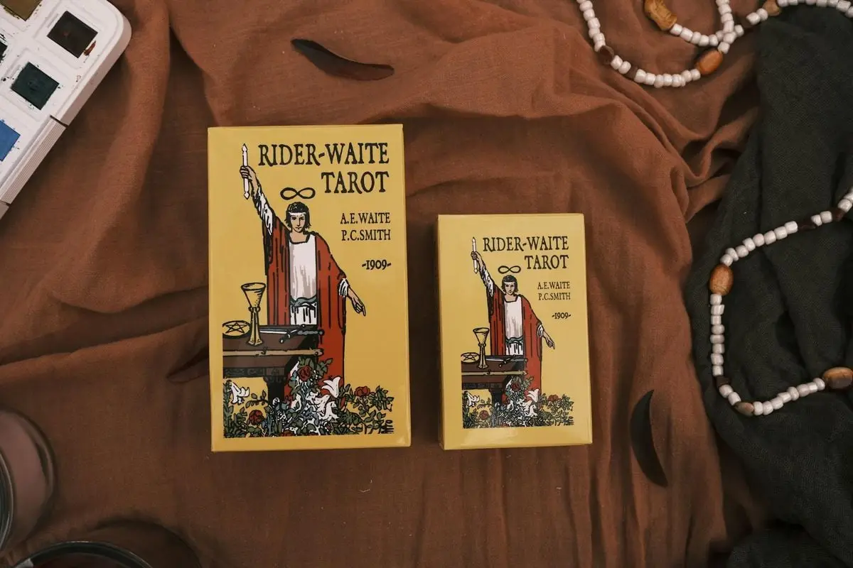 A flat lay of Rider-Waite Tarot cards surrounded by decorative beads and fabric, perfect for mystical themes.