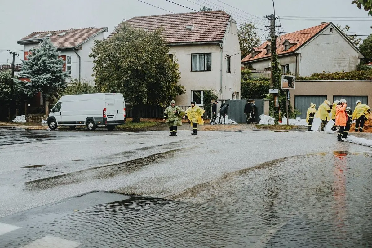 Emergency response team members handle city flooding, deploying sandbags and wearing gear.