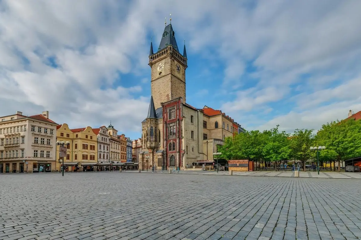 Scenic view of the iconic Old Town Square in Prague featuring historic architecture and the town hall tower.