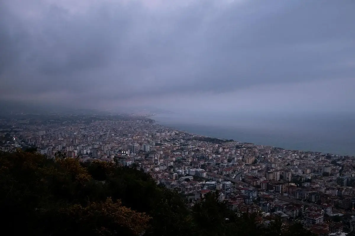 Explore the vast cityscape of Alanya, Turkey under a dramatic cloudy sky.