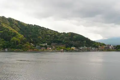 Peaceful landscape of Lake Kawaguchi with lush hills and cloudy sky, ideal for travel inspiration.