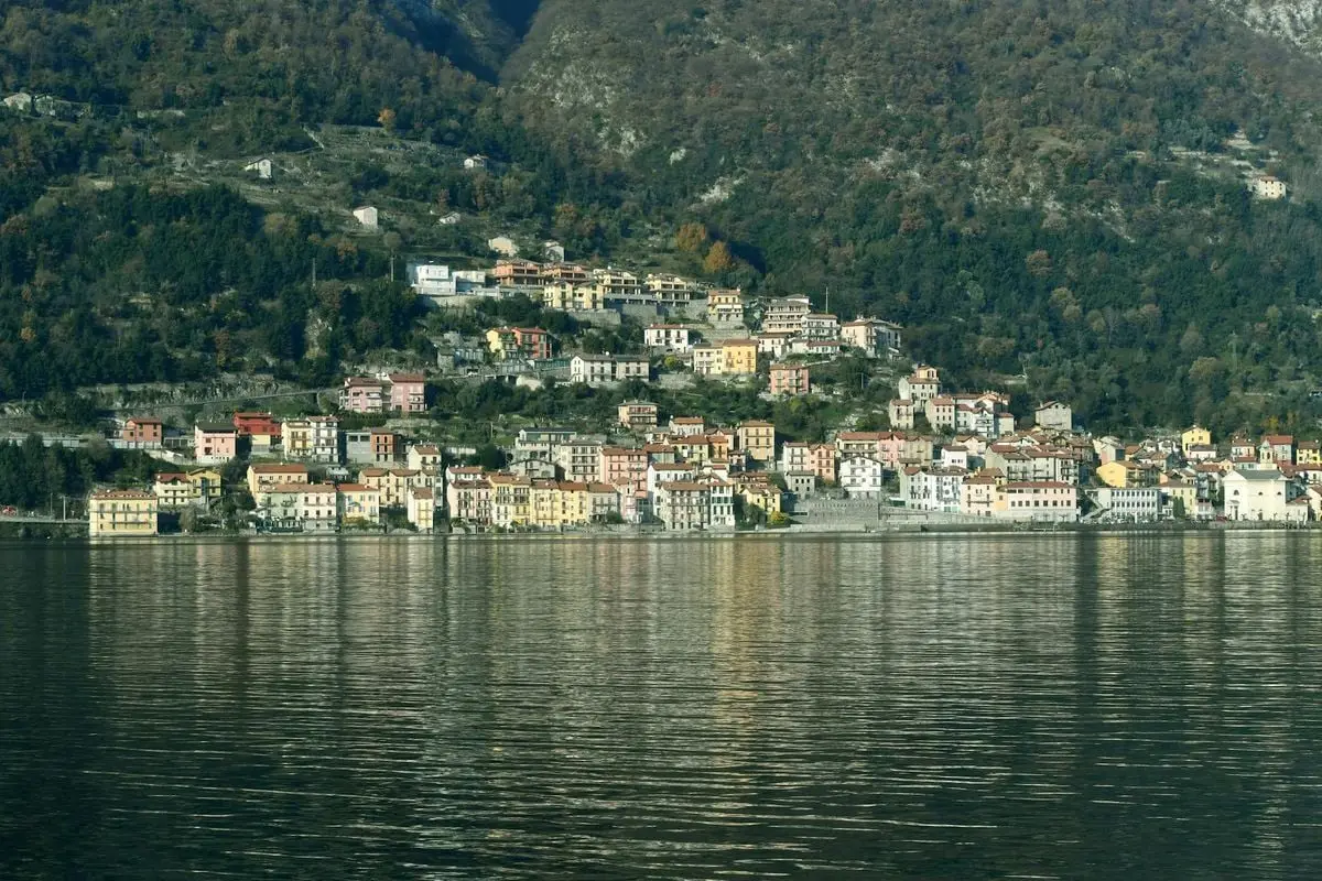 Picturesque view of Colonno, Lombardy, with colorful houses along Lake Como.
