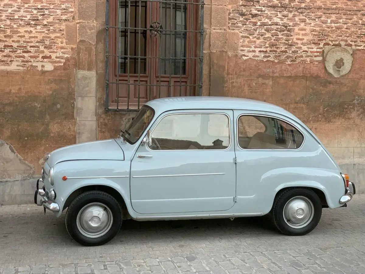 Classic vintage car parked by an old brick wall in Cabra del Santo Cristo, Spain.