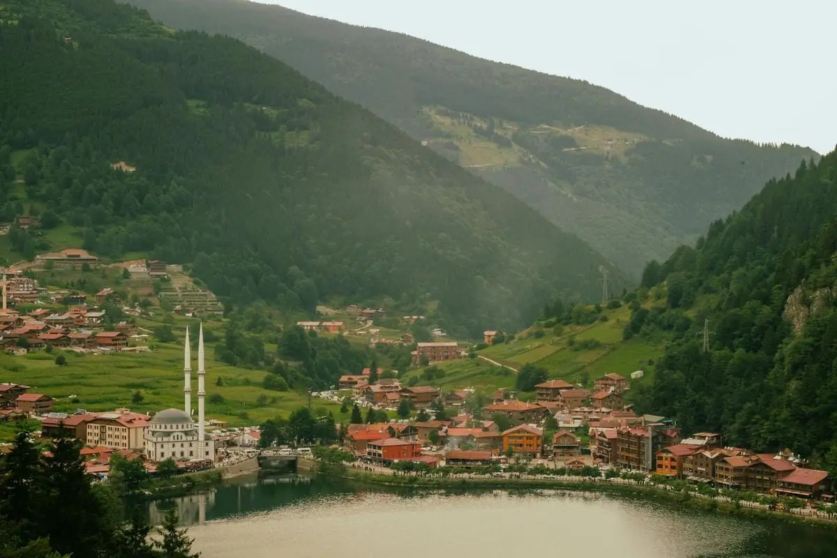 Idyllic view of Uzungöl village by the lake surrounded by lush hills in summer.