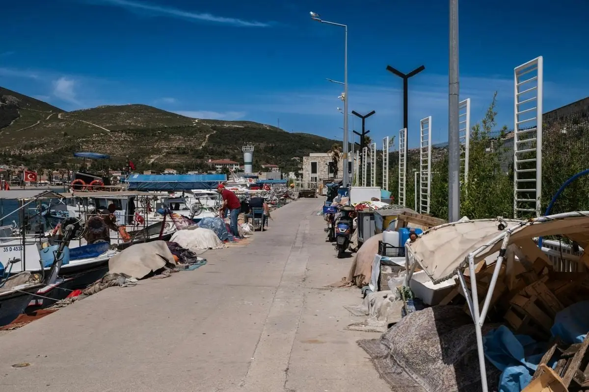 A serene view of a marina in Foça, İzmir, with moored boats and clear blue skies.