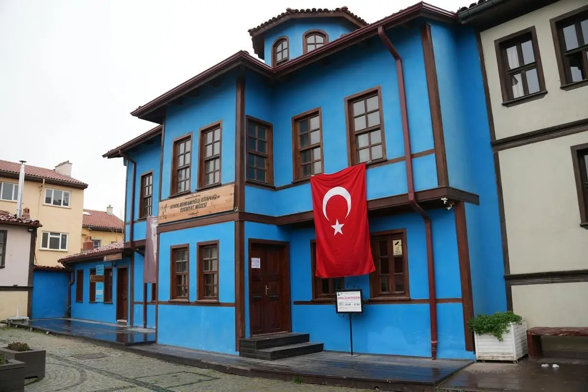 A vibrant blue Ottoman-style house in Turkey adorned with a Turkish flag.