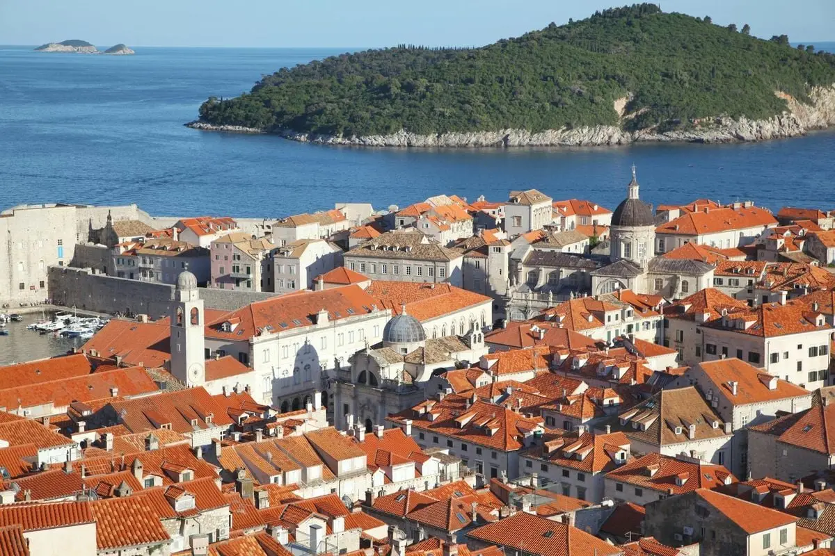 A stunning aerial view of Dubrovnik's historic Old Town by the sea, showcasing its iconic red rooftops.