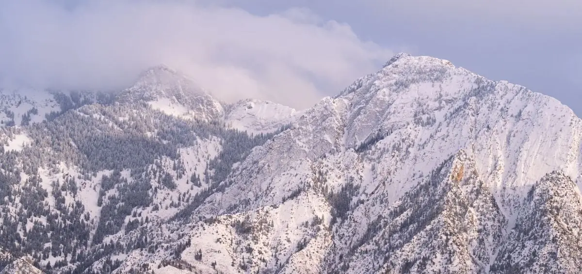 A scenic view of the Wasatch Mountains covered in spring snow near Salt Lake City, Utah.