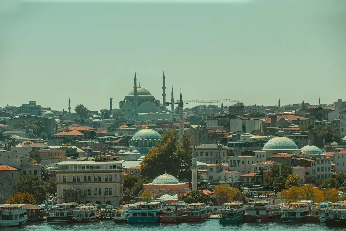 Explore the enchanting skyline of Istanbul featuring iconic mosques and bustling waterways with colorful boats.