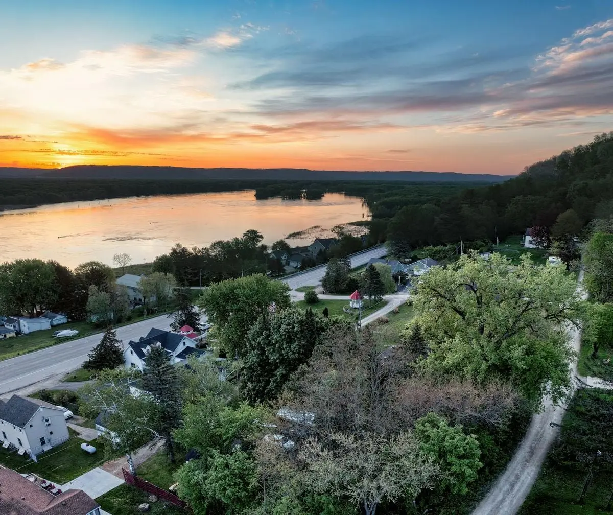 A stunning sunset over Reads Landing, Minnesota showing a lakeside townscape with vibrant skies.