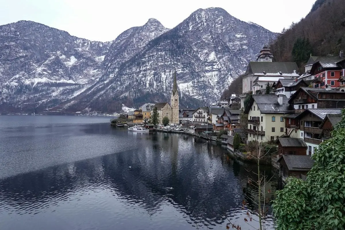 Charming winter landscape of Hallstatt with snow-capped mountains and a serene lake.