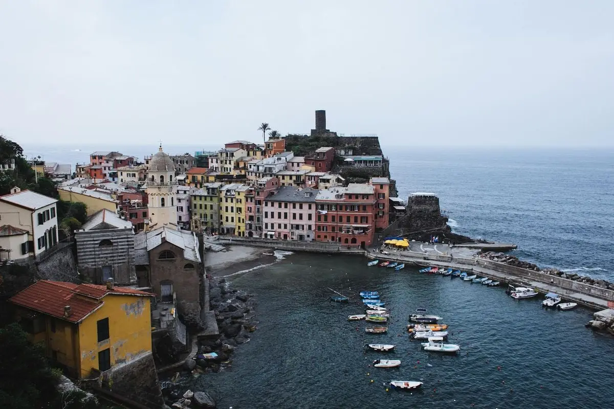 From above of small coastal town with boats floating on sea water near pier