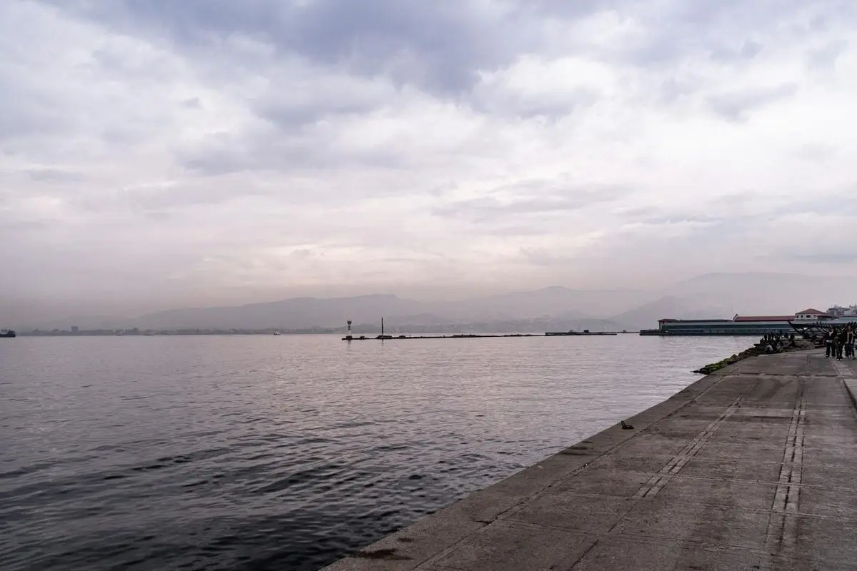 A serene view of İzmir Gulf with a cloudy sky and tranquil waters.