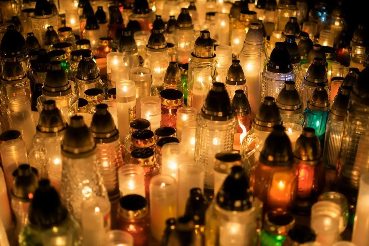 A warm glow of candles illuminates the cemetery for All Saints' Day.