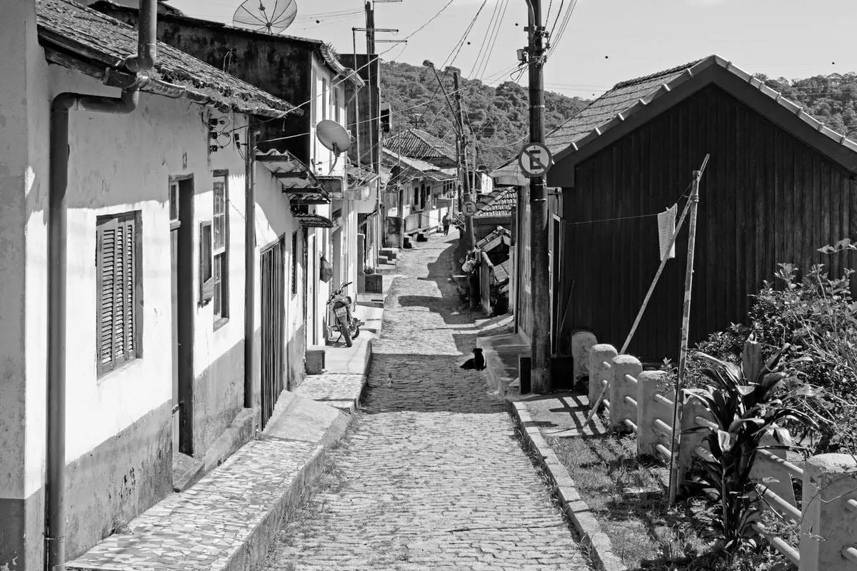 A picturesque cobblestone street in a quaint village, captured in black and white.