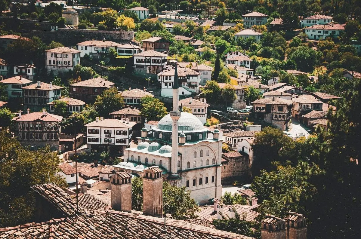 Aerial view of a Turkish village with traditional Ottoman houses and a prominent mosque.