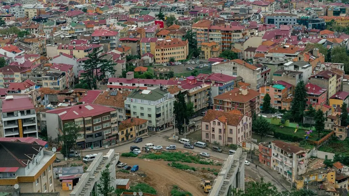 Vibrant aerial shot of a densely-packed urban area in Turkey, featuring colorful rooftops and lush greenery.