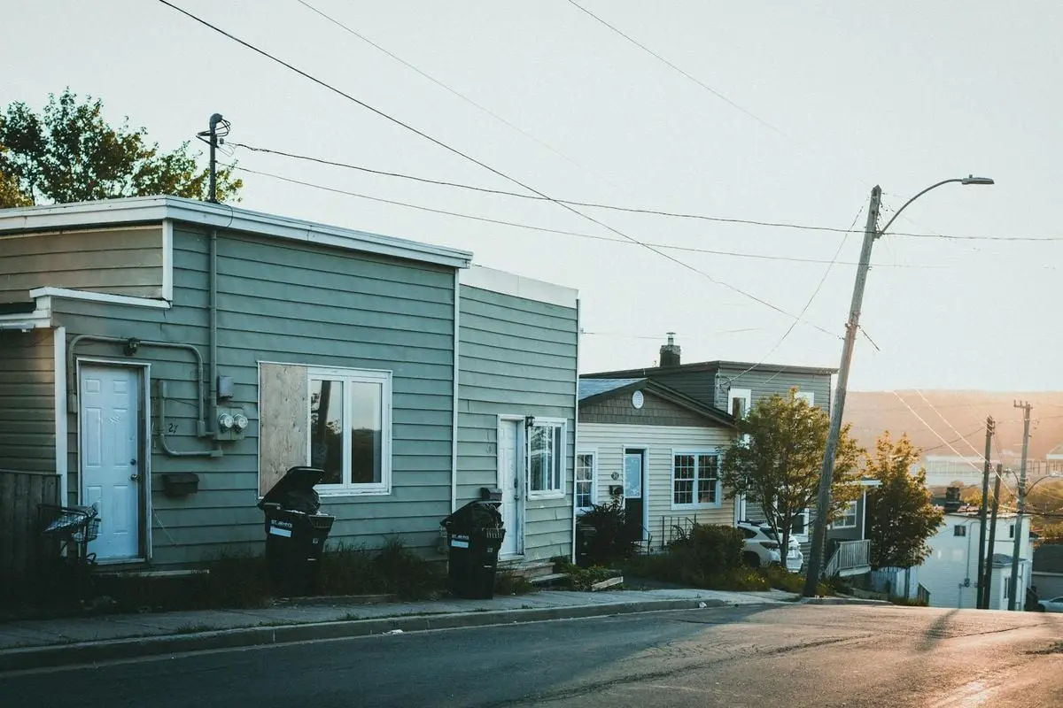 Serene small town street with wooden houses at sunset, creating a warm and tranquil atmosphere.