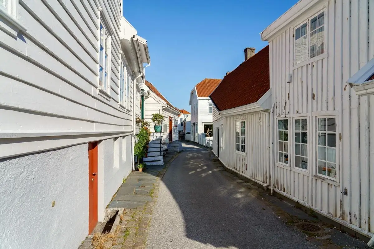 Explore the charming heritage architecture of Skudeneshavn's narrow streets on a sunny day.
