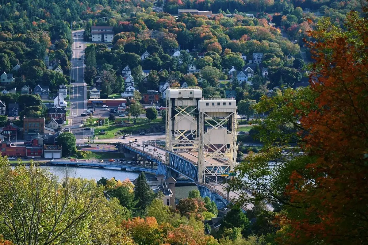 Aerial view of Portage Canal Lift Bridge amidst fall foliage in Michigan's Upper Peninsula.