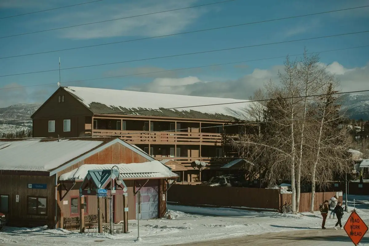 Winter scene with snow-covered rustic buildings and mountains in Colorado.