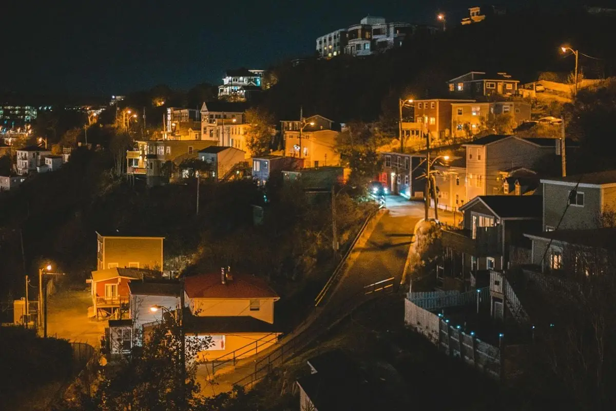 City with small settlement of cottages with bright lights in late clear evening