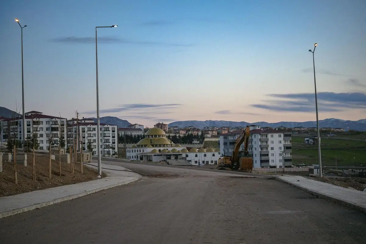 Capture of Palu, Elazığ showcasing buildings, a mosque, and construction at twilight.